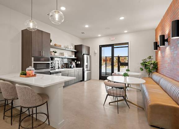 A modern kitchen with a bar area and a dining table.