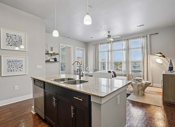 A modern kitchen with a large island and a view of the city.