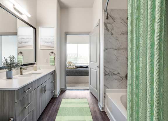 A bathroom with a green shower curtain and a white sink.