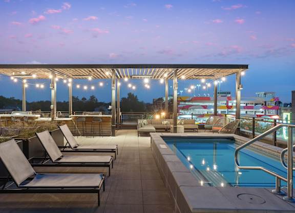 A pool area with sun loungers and a roofed seating area.