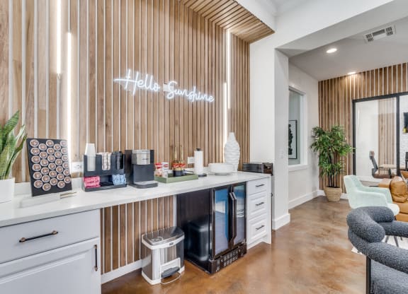 a hotel lobby with a counter with coffee machines and a sign on the wall