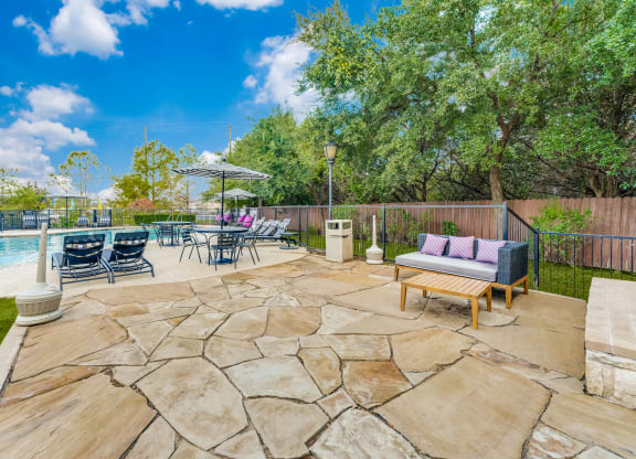 the backyard has a pool and patio with furniture and chairs