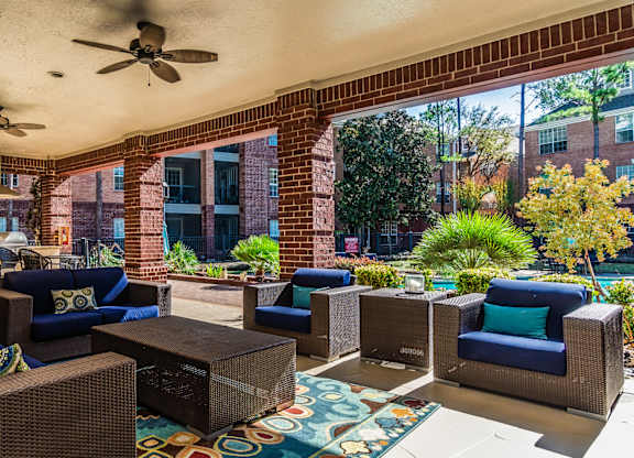 A patio with a wicker sofa and chairs.