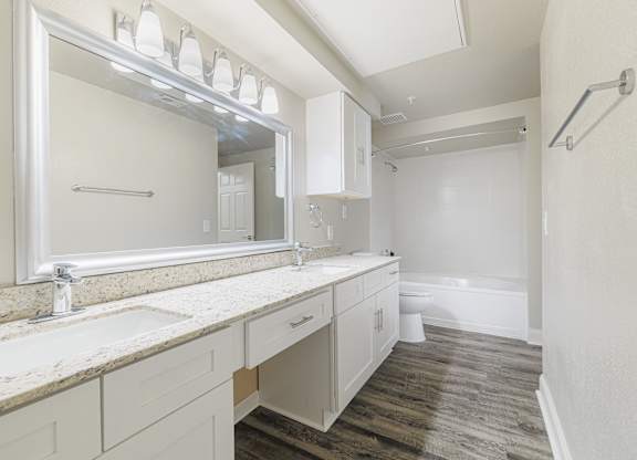 a bathroom with a large mirror and a sink and a toilet