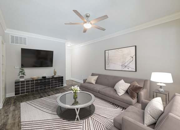 a living room with a couch and a table and a ceiling fan