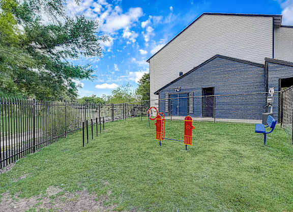 a large yard with two fire hydrants in the middle and a building in the background