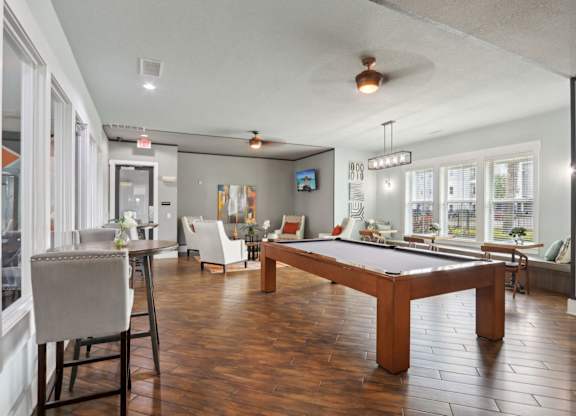 A room with a pool table and a television.