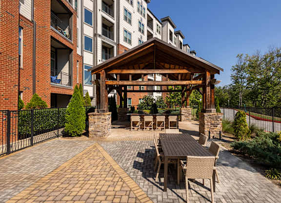 a patio with a table and chairs outside of an apartment building