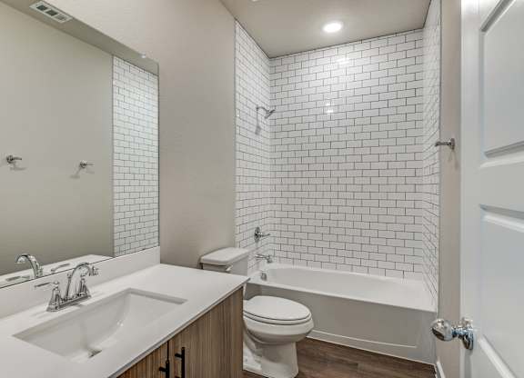 A white bathroom with a sink, toilet, and bathtub.