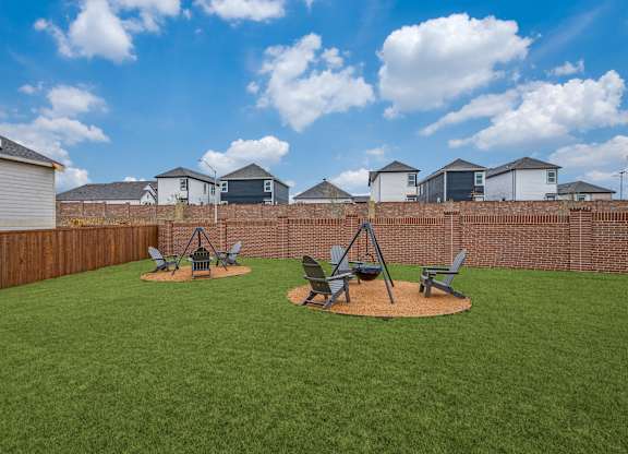 A backyard with a lawn and a swing set.