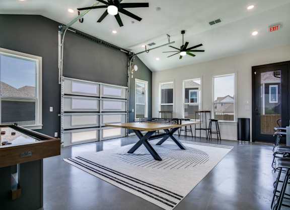 A room with a pool table and a ceiling fan.