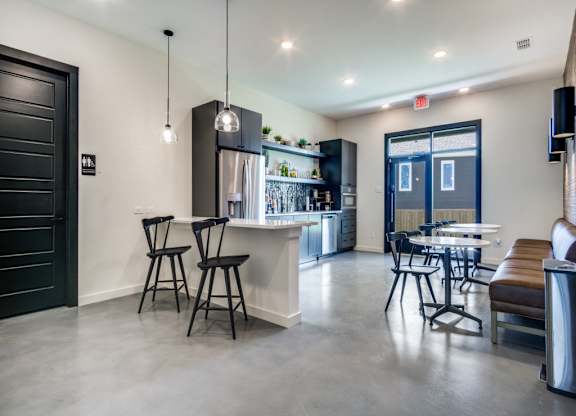 A modern kitchen with a bar area and a dining table.