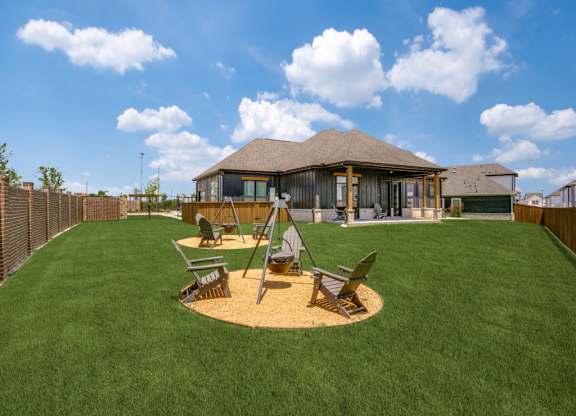 A house with a brown roof and a green lawn in front.