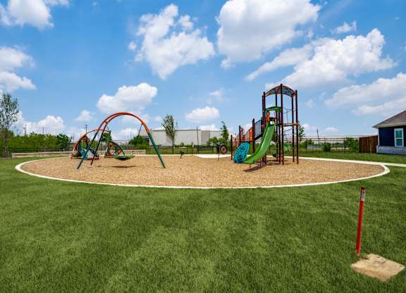 A playground with a green slide and a red swing set.