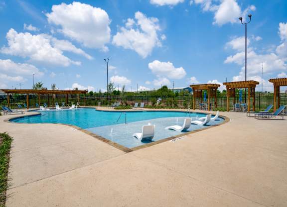 A large outdoor swimming pool with a sun lounger.