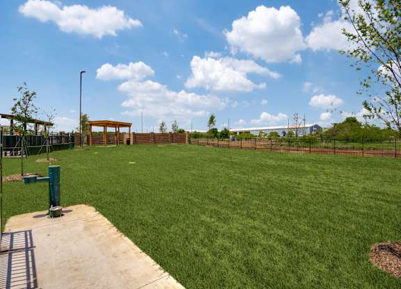 A large grassy field with a wooden structure in the distance.
