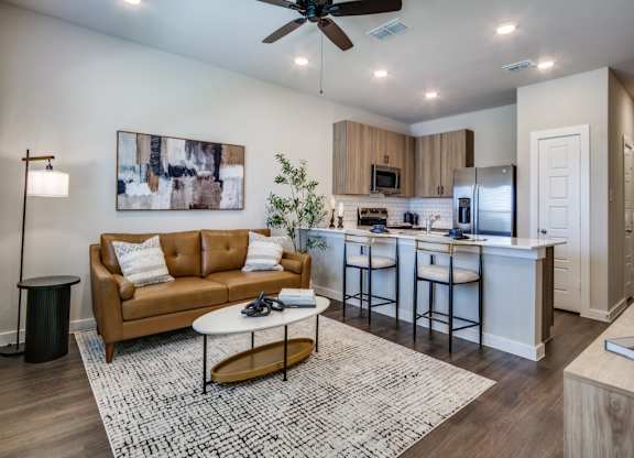 A modern living room with a brown sofa and a white coffee table.