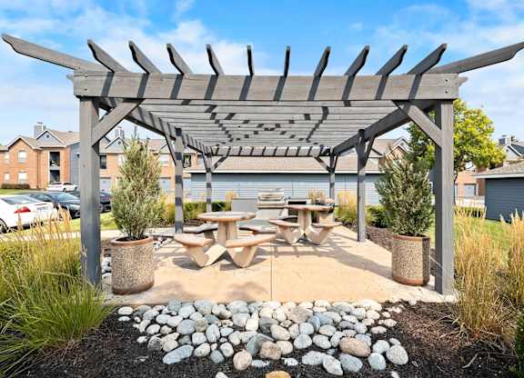 A wooden pergola with a picnic table underneath it.