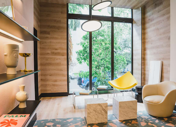 A yellow chair sits in a room with a large window.