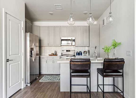 A kitchen with a white cabinet and a white fridge.