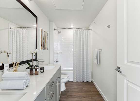 A white bathroom with a toilet, sink, and shower.