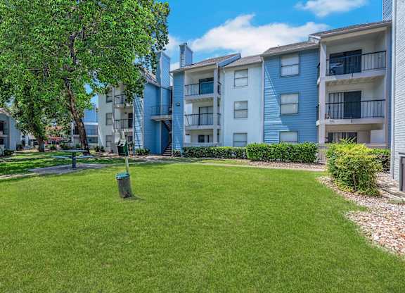 A grassy area in front of apartment buildings.