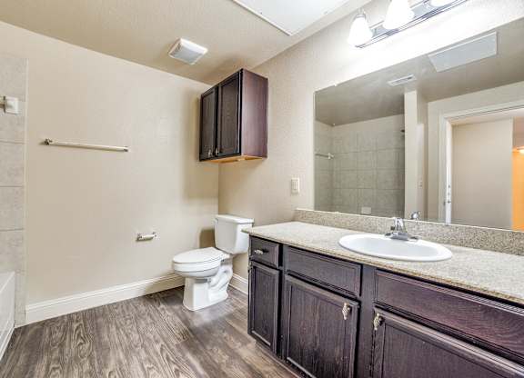 an empty bathroom with a toilet sink and mirror