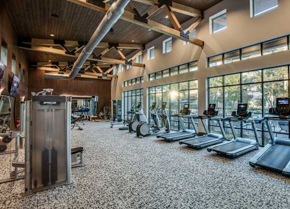 A gym with treadmills, weights, and exercise equipment.