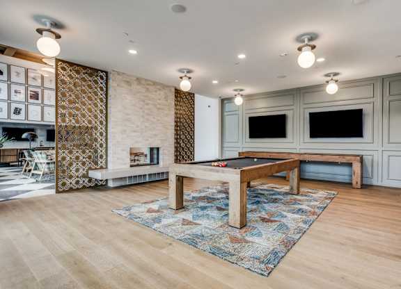 A room with a pool table and a patterned rug.