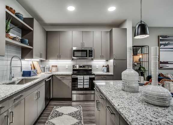 A modern kitchen with granite countertops and stainless steel appliances.