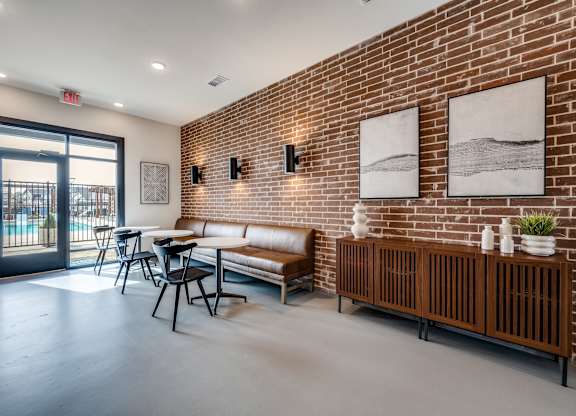 A room with a brick wall and a bench.