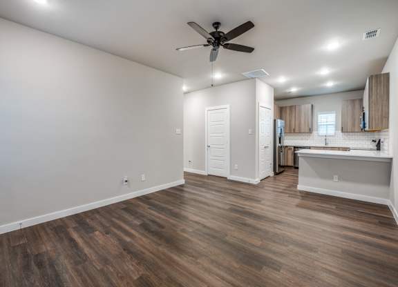 A room with a ceiling fan and wooden flooring.