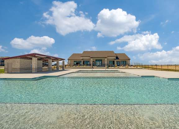 A large swimming pool in front of a house.