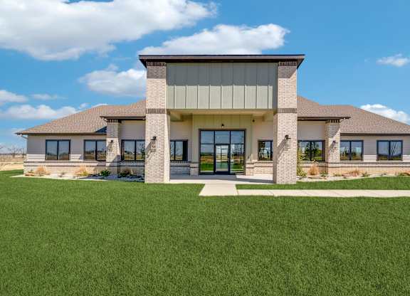 A modern house with a large front yard.