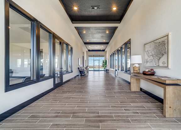 A long hallway with a bench and a map on the wall.
