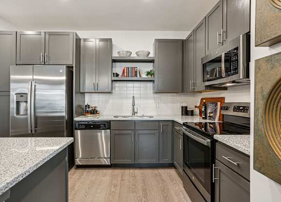 A modern kitchen with stainless steel appliances and dark wood cabinets.