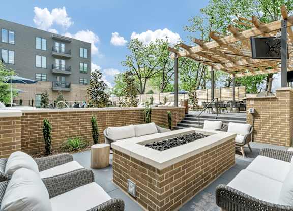 A patio with a fire pit and seating area.