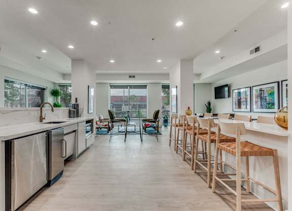 A modern kitchen with wooden floors and white countertops.