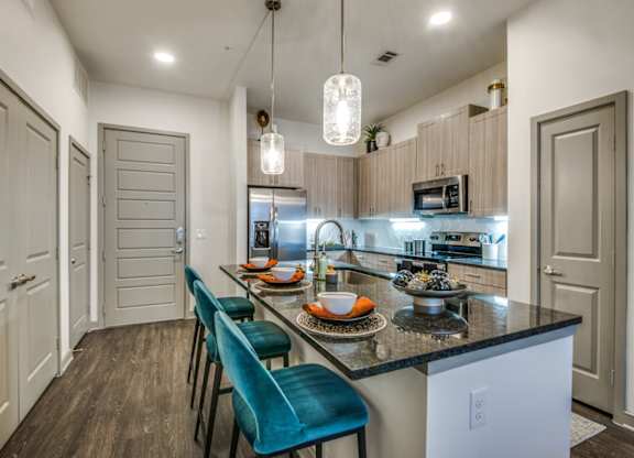 A kitchen with a table and chairs in front of a counter.