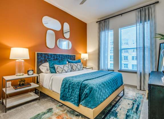 A bedroom with a bed, nightstand, and window.