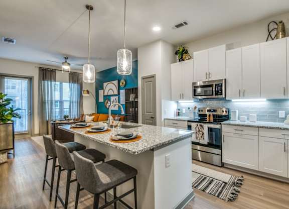 A kitchen with a white countertop and a blue backsplash.