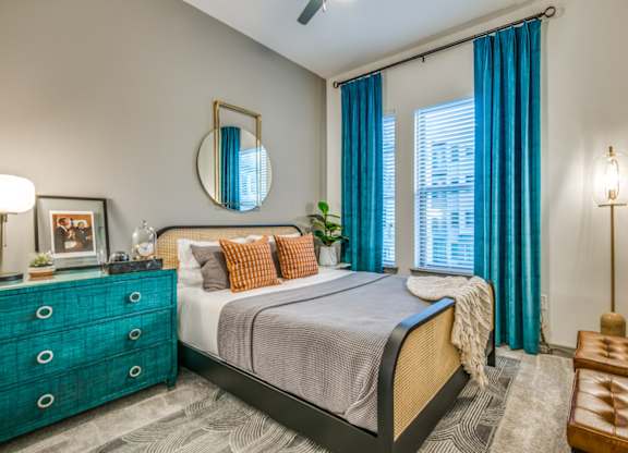 A bedroom with a bed, dresser, and mirror.
