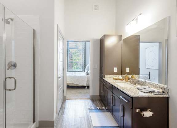 a bathroom with a shower and a sink and a mirror