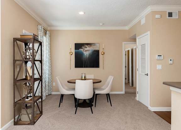 A dining room with a table set for four.