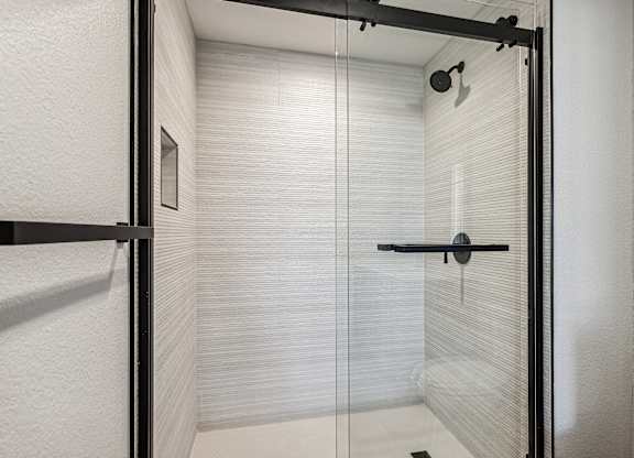 A white bathroom with a glass shower door.