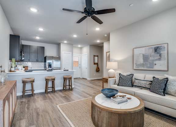 A modern living room with a ceiling fan and a white couch.