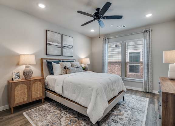A bedroom with a bed, a ceiling fan, and a rug.