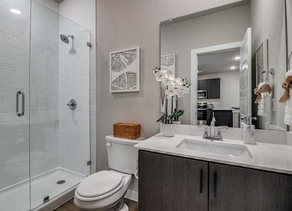A bathroom with a toilet, sink, and shower.