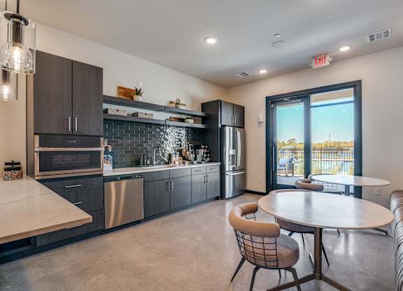 A modern kitchen with a dining table and chairs.