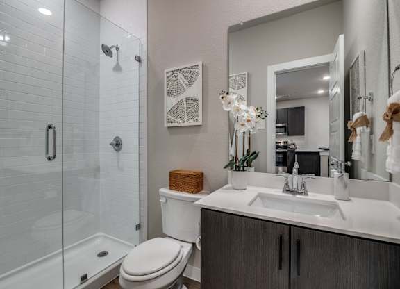 A bathroom with a toilet, sink, and shower.